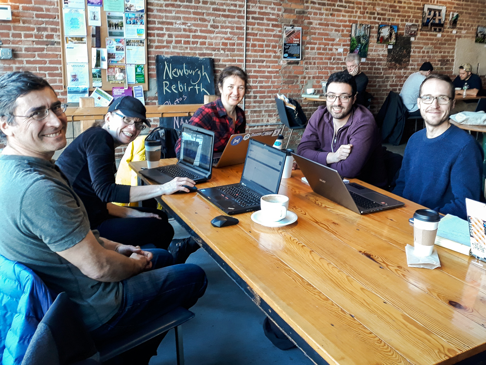 industry mentors and others seated around a table in a cafe